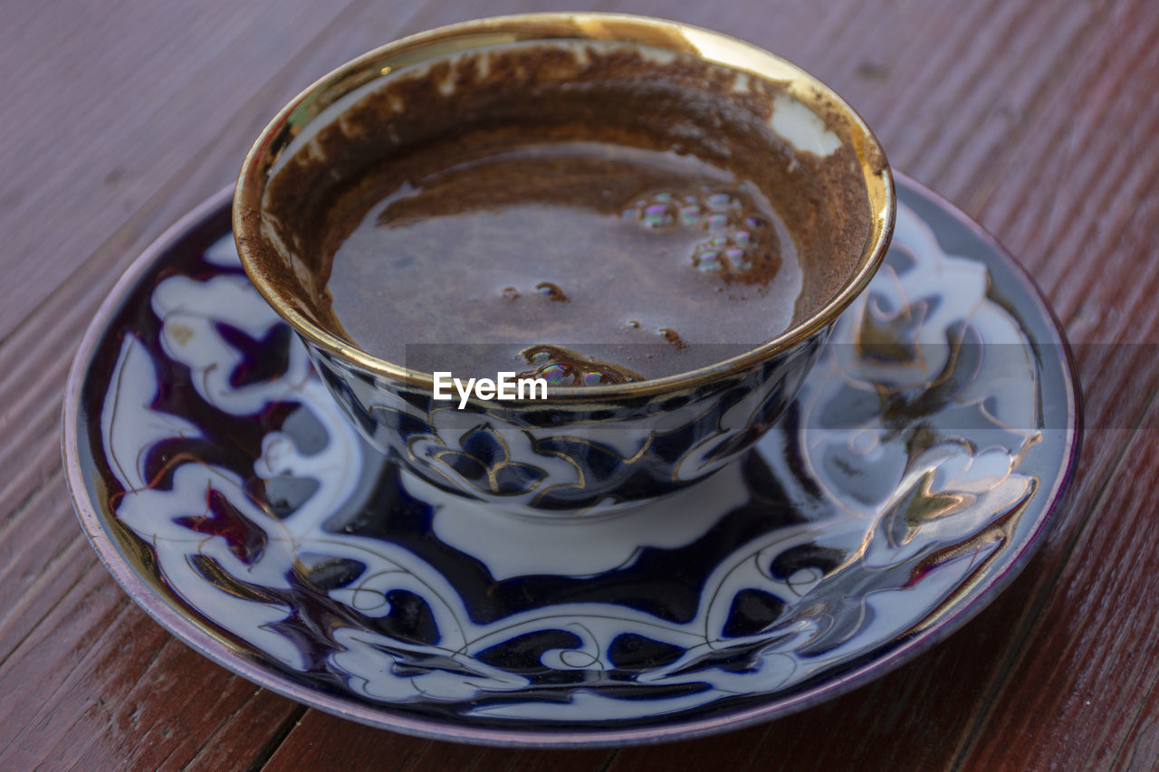 HIGH ANGLE VIEW OF COFFEE IN CUP ON TABLE