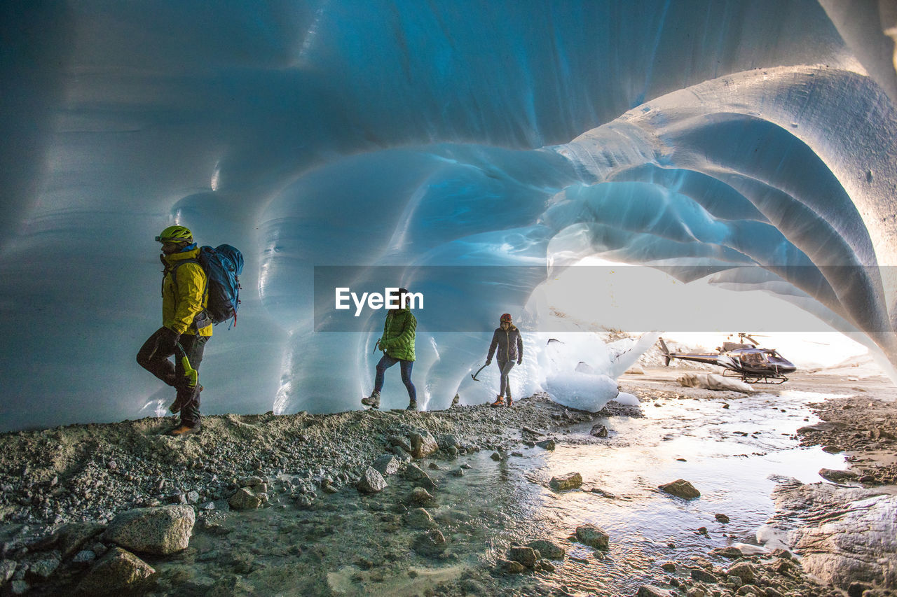 Adventure guide brings two female clients into a glacial cave.