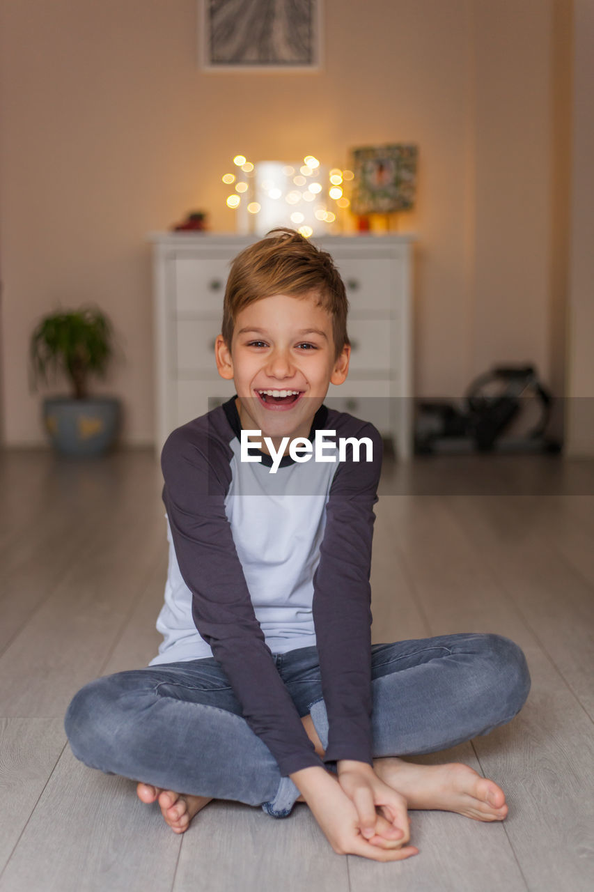 Portrait of smiling boy sitting at home