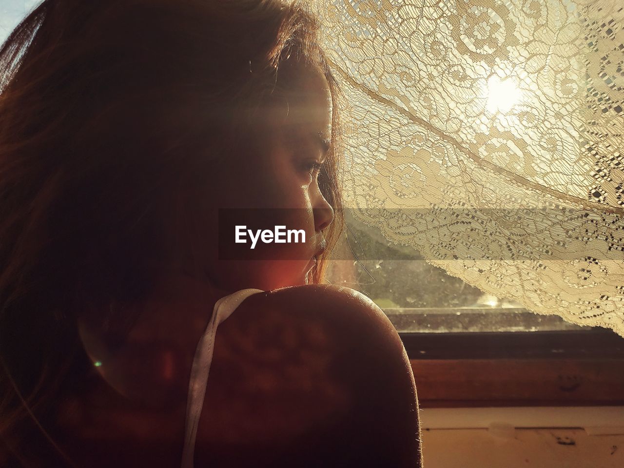 PORTRAIT OF GIRL LOOKING THROUGH WINDOW IN CAR