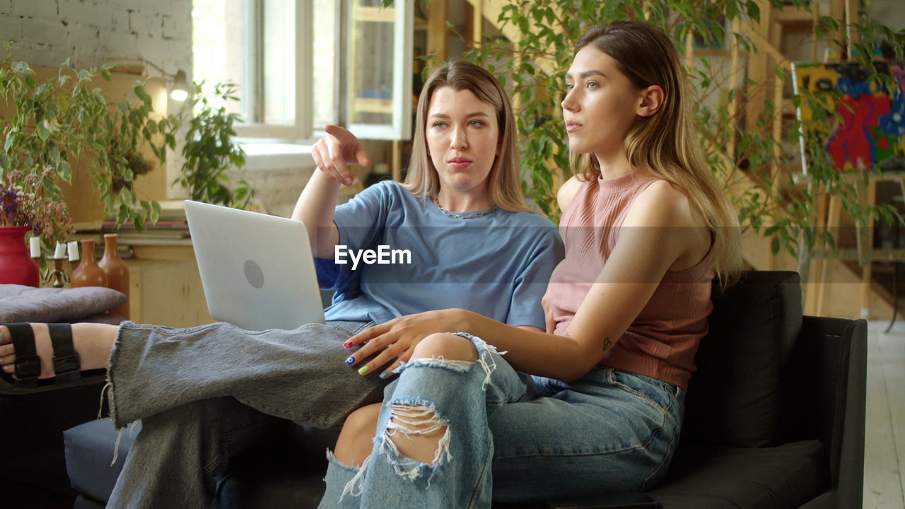 Lesbian couple talking while sitting at home