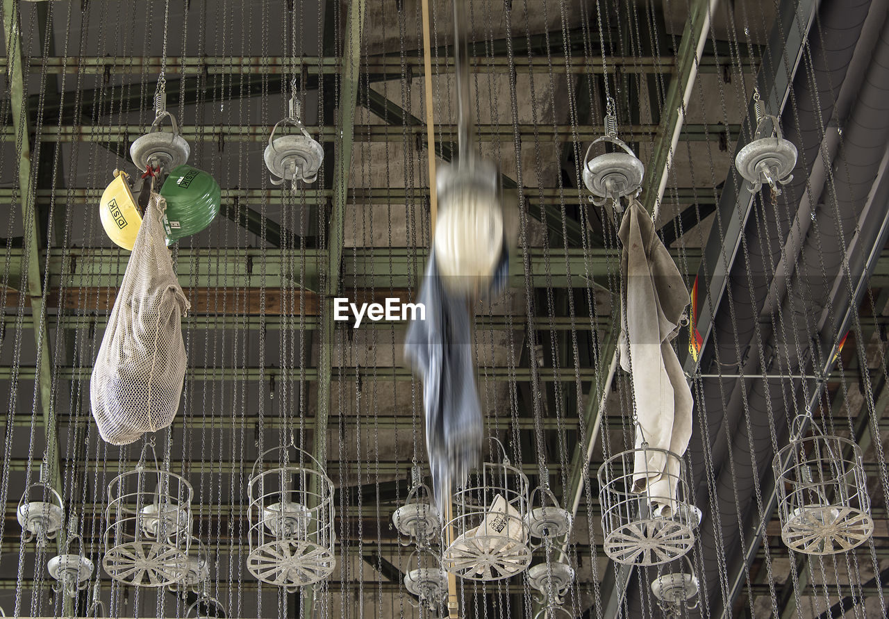 LOW ANGLE VIEW OF METAL HANGING IN CAGE