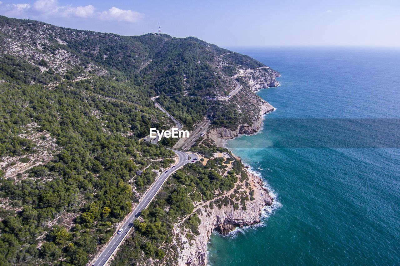 High angle view of sea by mountains against sky