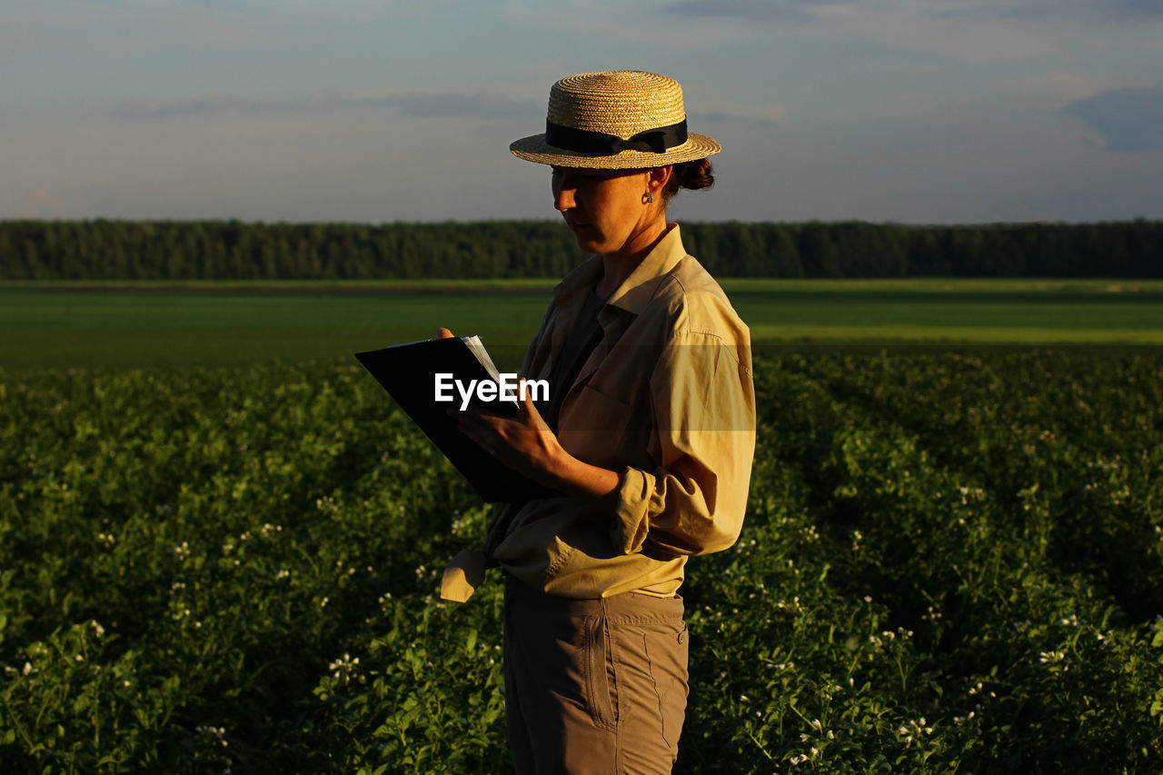 The farmer controls the quality of the potato crop. female agronomist in agriculture