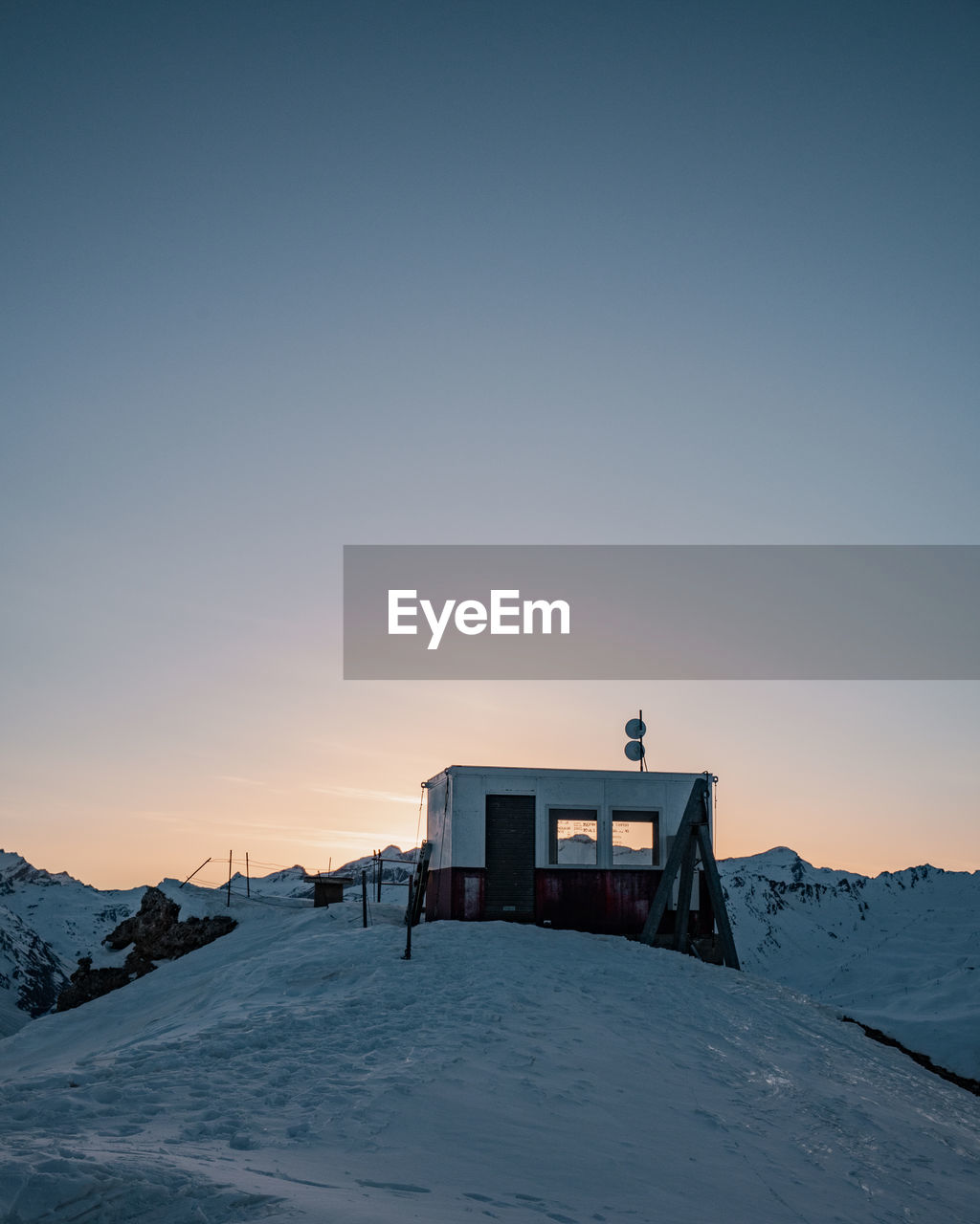 SNOW COVERED BUILDING AGAINST SKY DURING WINTER