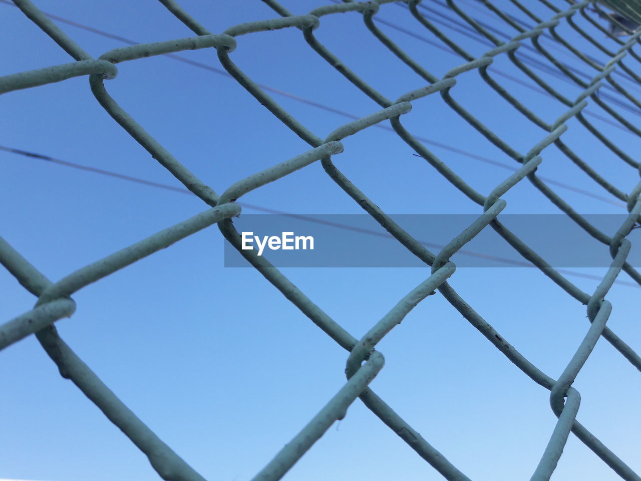 LOW ANGLE VIEW OF BLUE SKY SEEN THROUGH METAL STRUCTURE