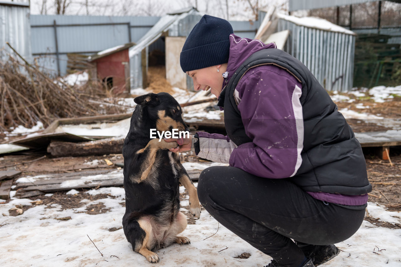 Girl volunteer in the nursery for dogs. shelter for stray dogs.