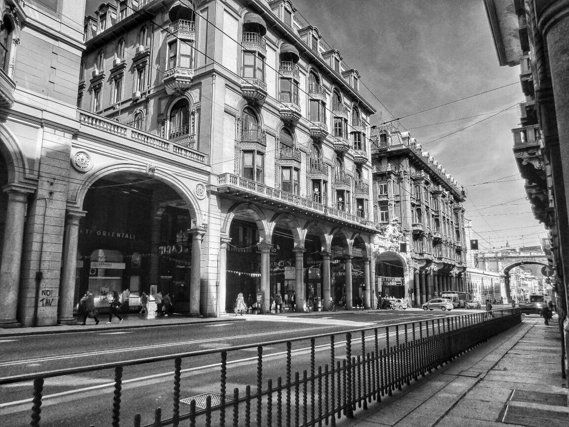 Sidewalk by street and buildings against sky in city