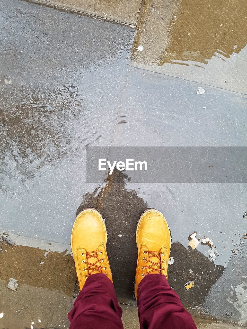 LOW SECTION OF MAN STANDING ON YELLOW WATER