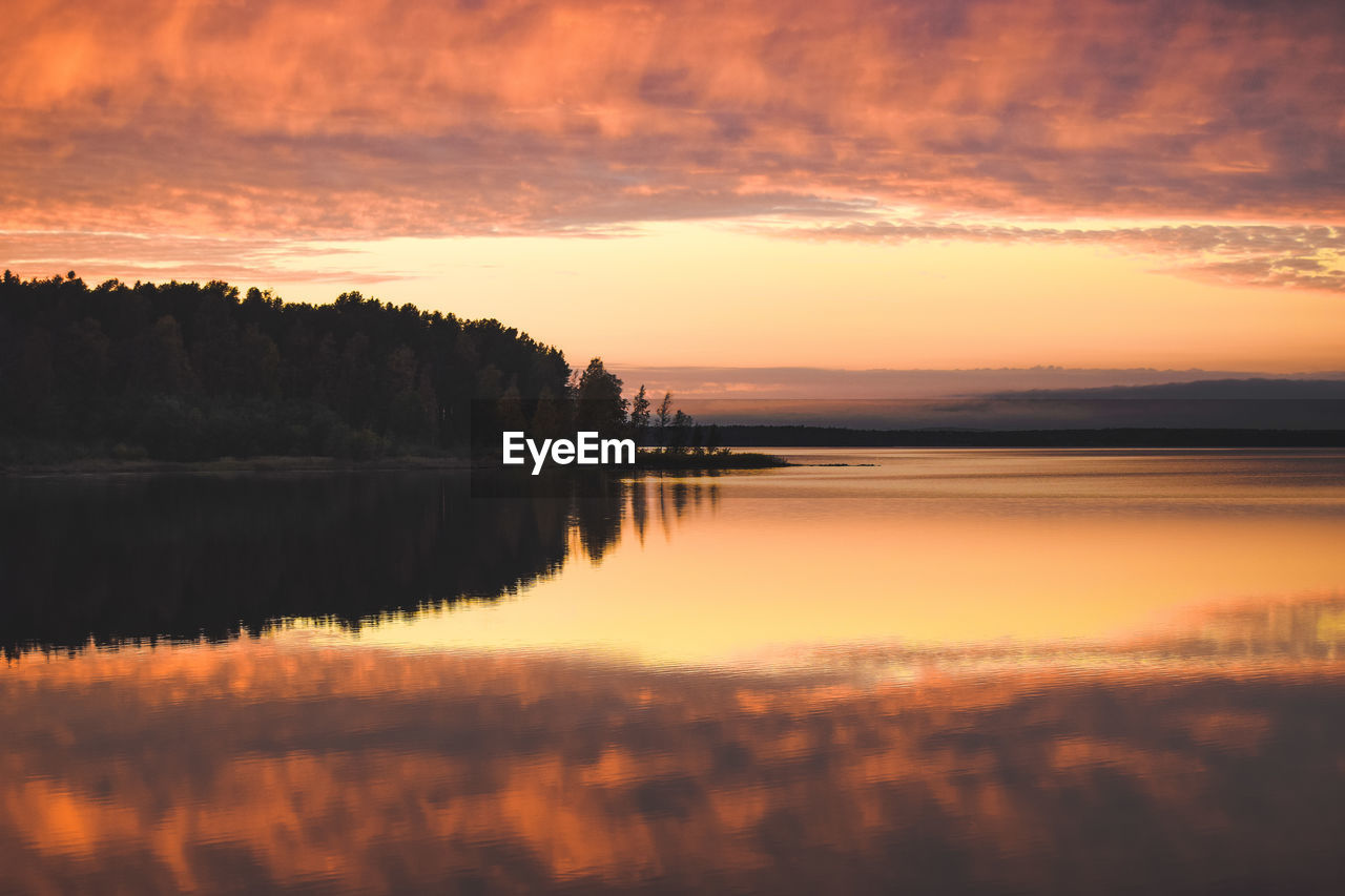 Scenic view of lake against orange sky