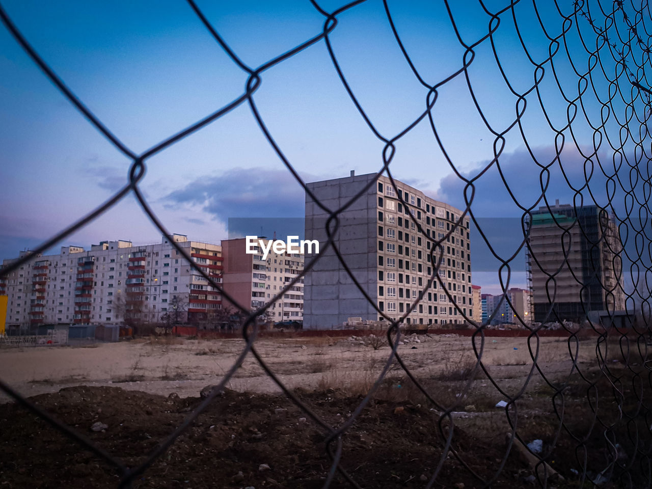 View of city seen through chainlink fence