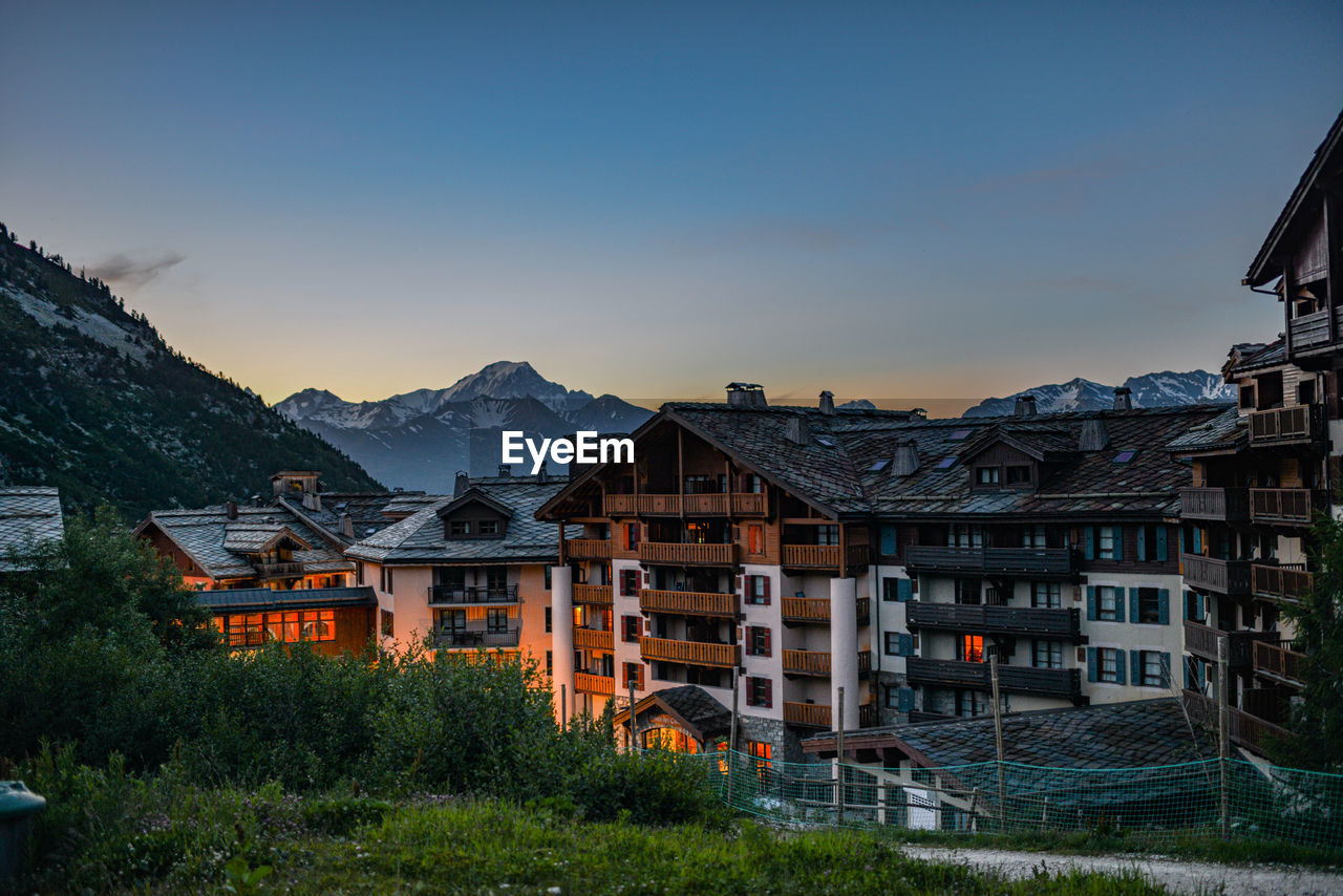 Houses and buildings against sky at sunset