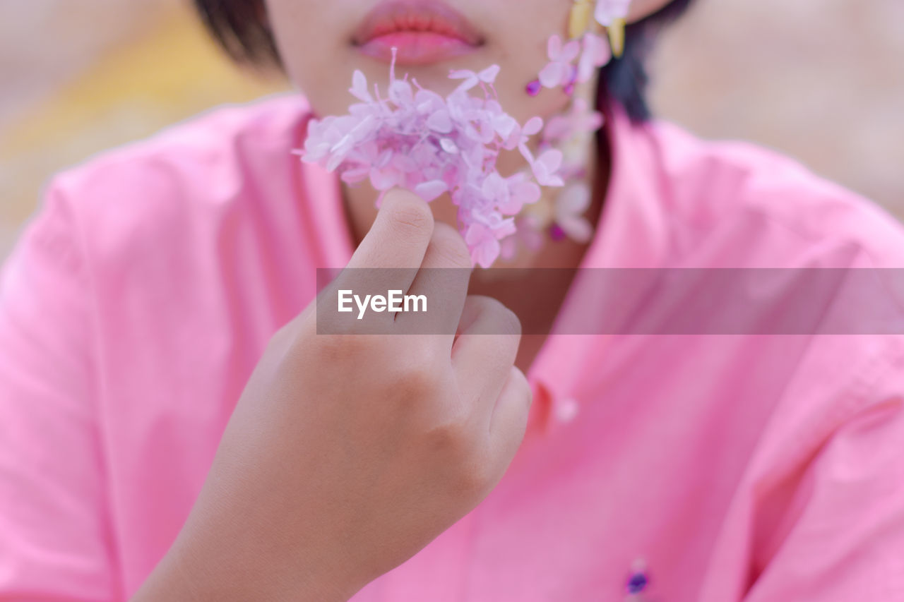 Close-up of woman holding pink rose flower