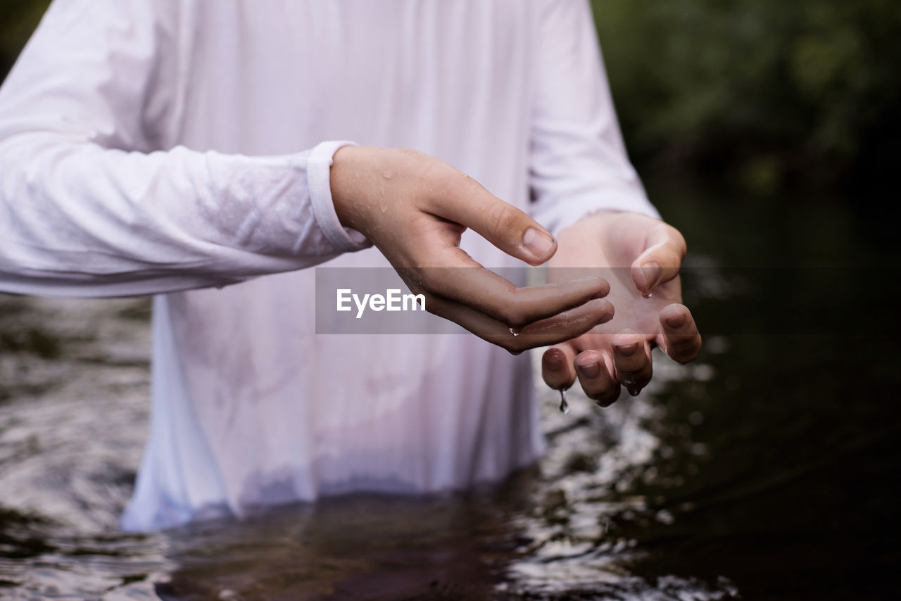 Midsection of man standing in river