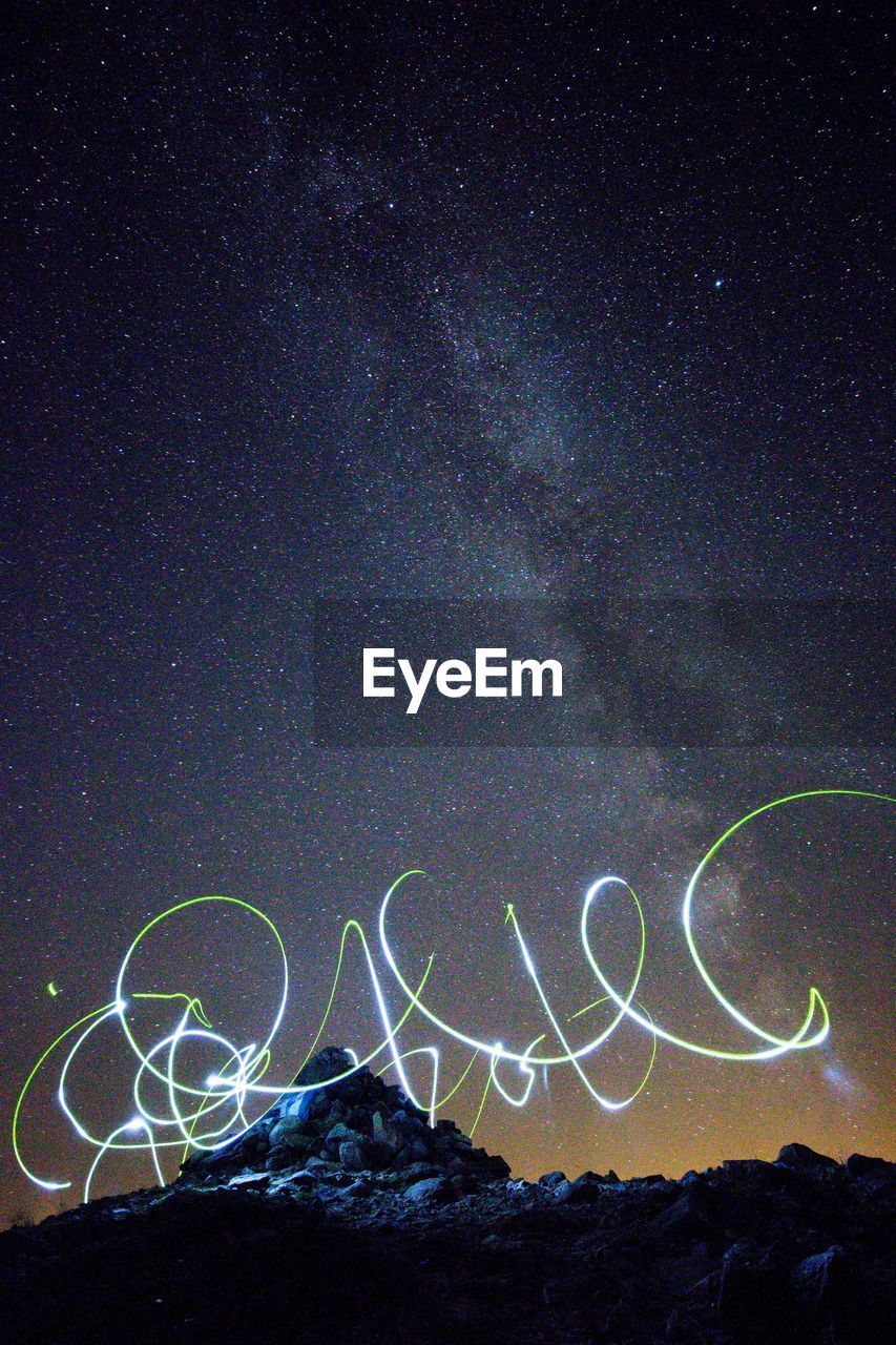 Low angle view of light painting against star field at night