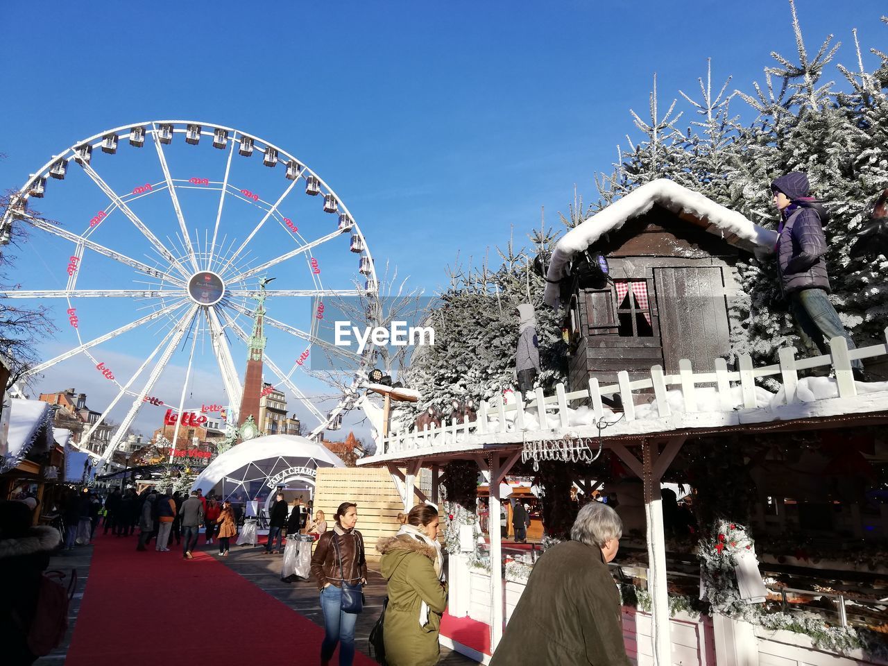 GROUP OF PEOPLE IN AMUSEMENT PARK AGAINST SKY