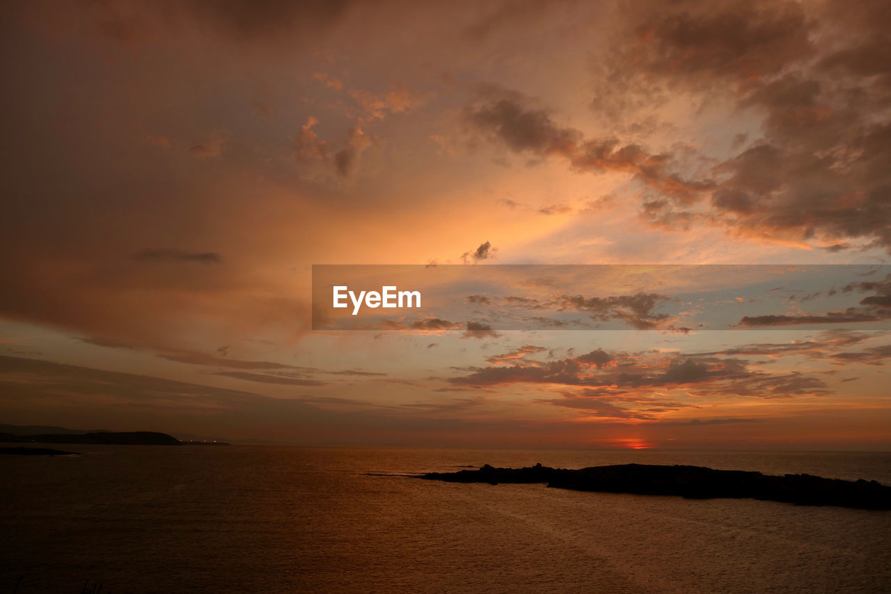 SCENIC VIEW OF BEACH AGAINST SKY DURING SUNSET