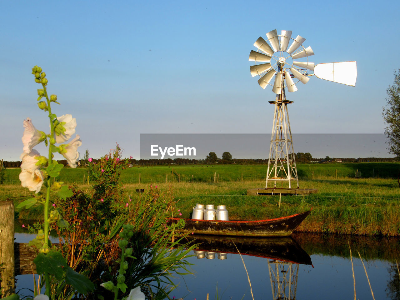 TRADITIONAL WINDMILL IN LAKE AGAINST SKY
