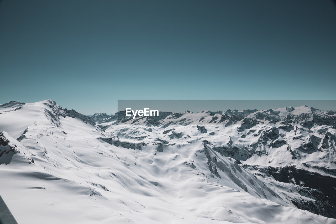 Scenic view of snowcapped mountains against clear sky