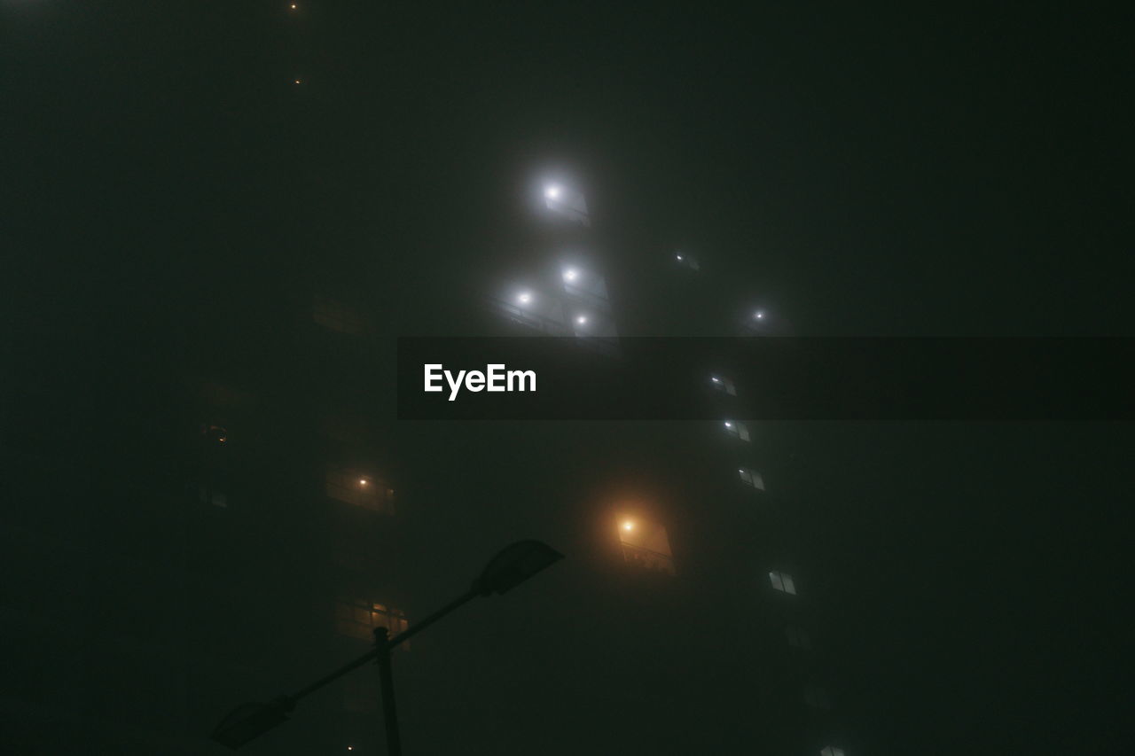 LOW ANGLE VIEW OF ILLUMINATED STREET LIGHTS AGAINST SKY