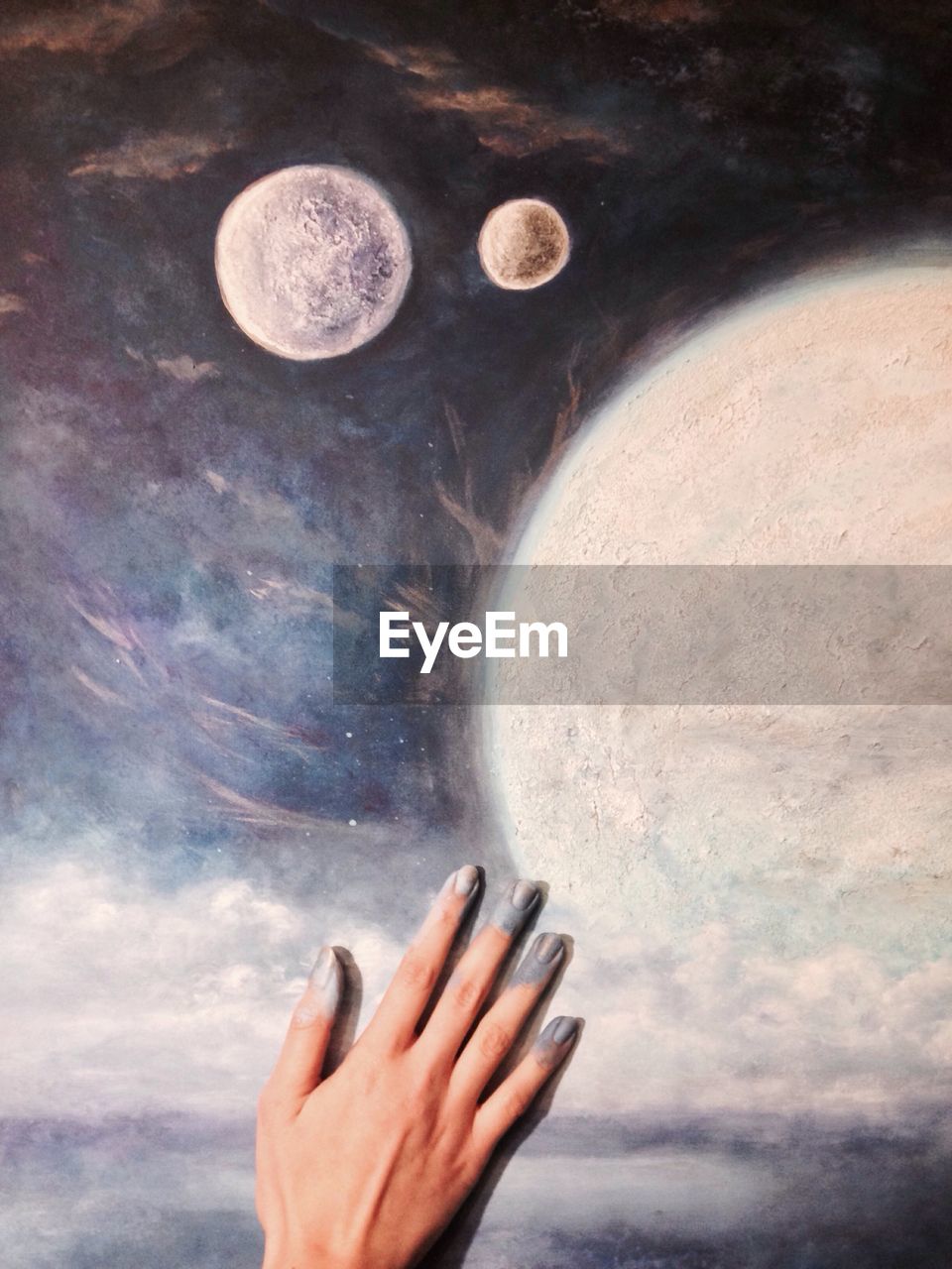 CLOSE-UP OF HAND AGAINST MOON