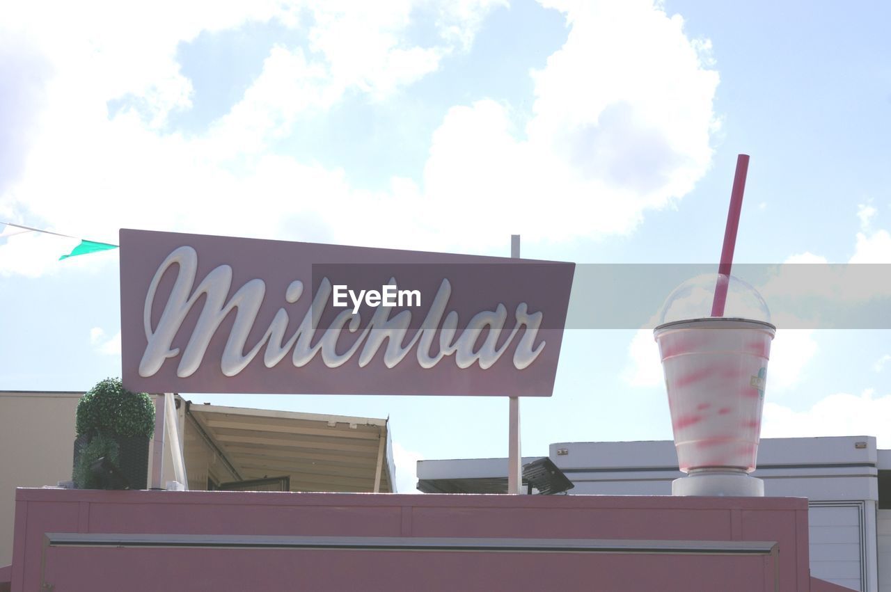 LOW ANGLE VIEW OF SIGN ON BUILDING AGAINST SKY