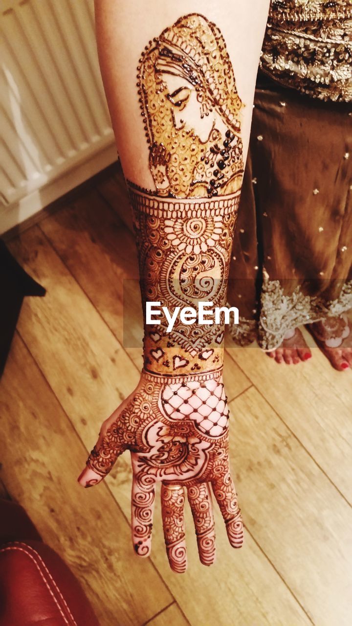 Low section of bride with henna tattoo on hand