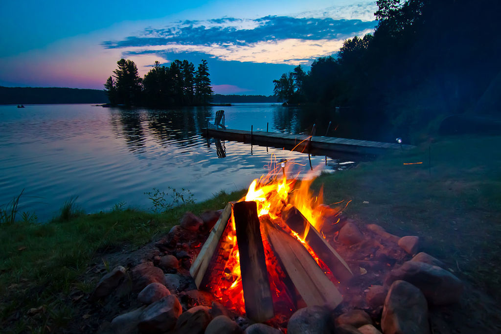 Bonfire on lakeshore during sunset