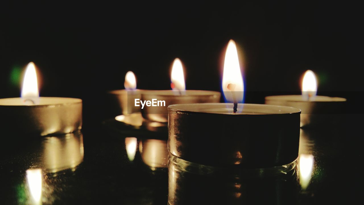 Lit tea light candles on table