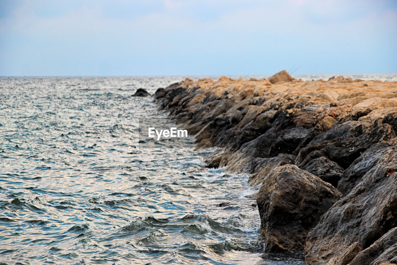 Rocks on beach against sky