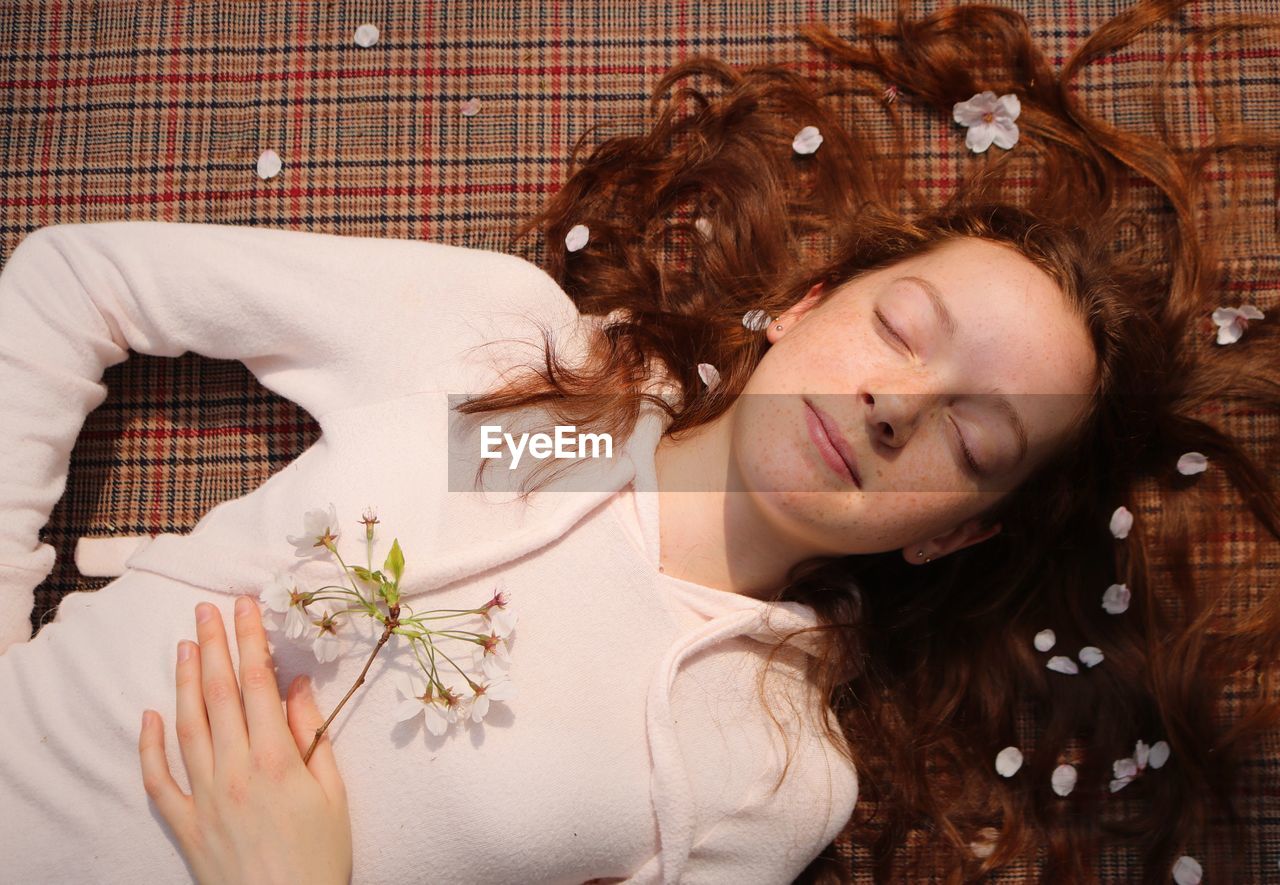 PORTRAIT OF YOUNG WOMAN LYING ON BED