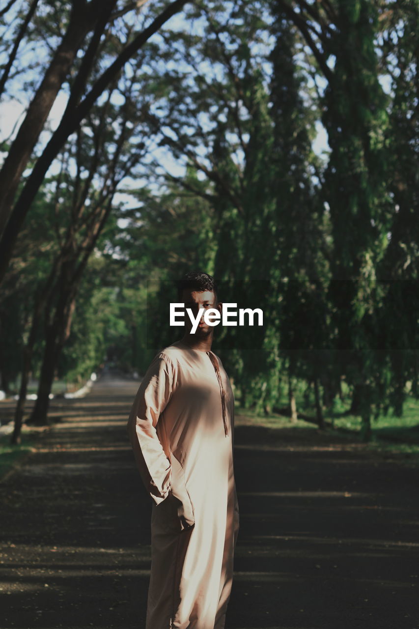 A portrait of a mixed race man in a light beige robe.