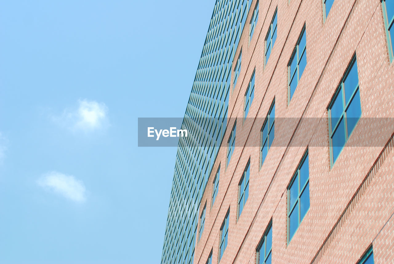 Low angle view of modern building against blue sky