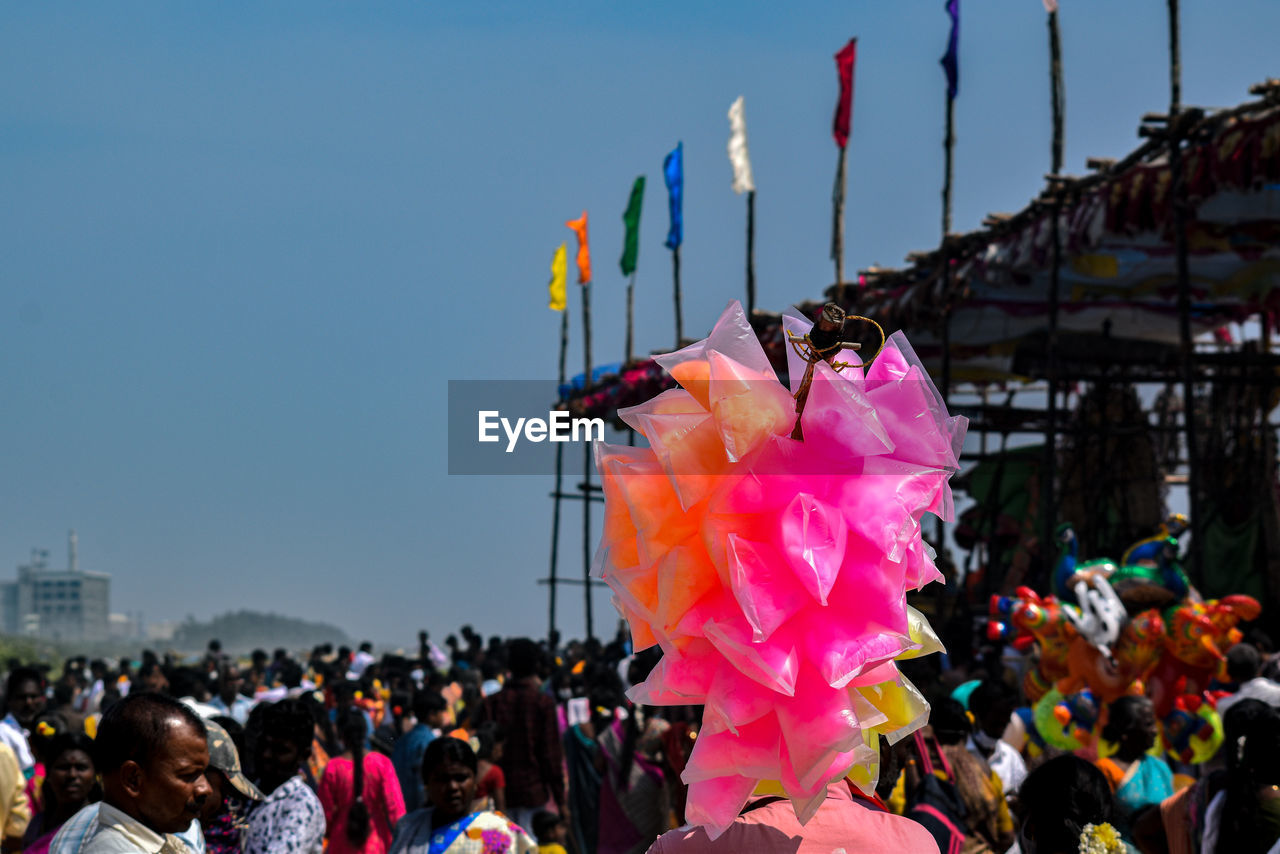 crowd, group of people, large group of people, sky, event, celebration, festival, tradition, nature, flag, women, architecture, carnival, adult, men, person, multi colored, day, outdoors, city, arts culture and entertainment, pink, lifestyles, leisure activity, clear sky, traditional festival