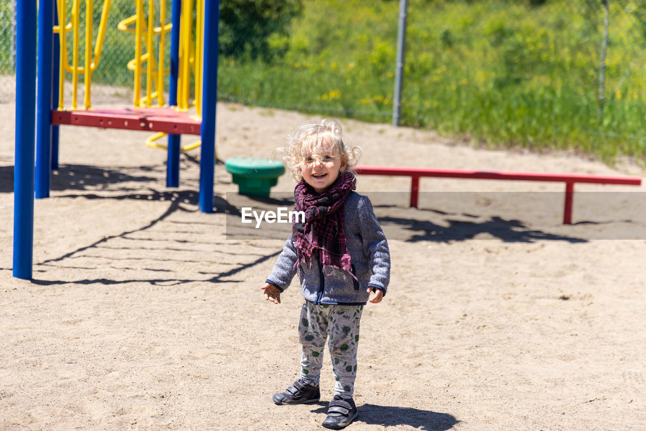 full length of girl standing on slide at park