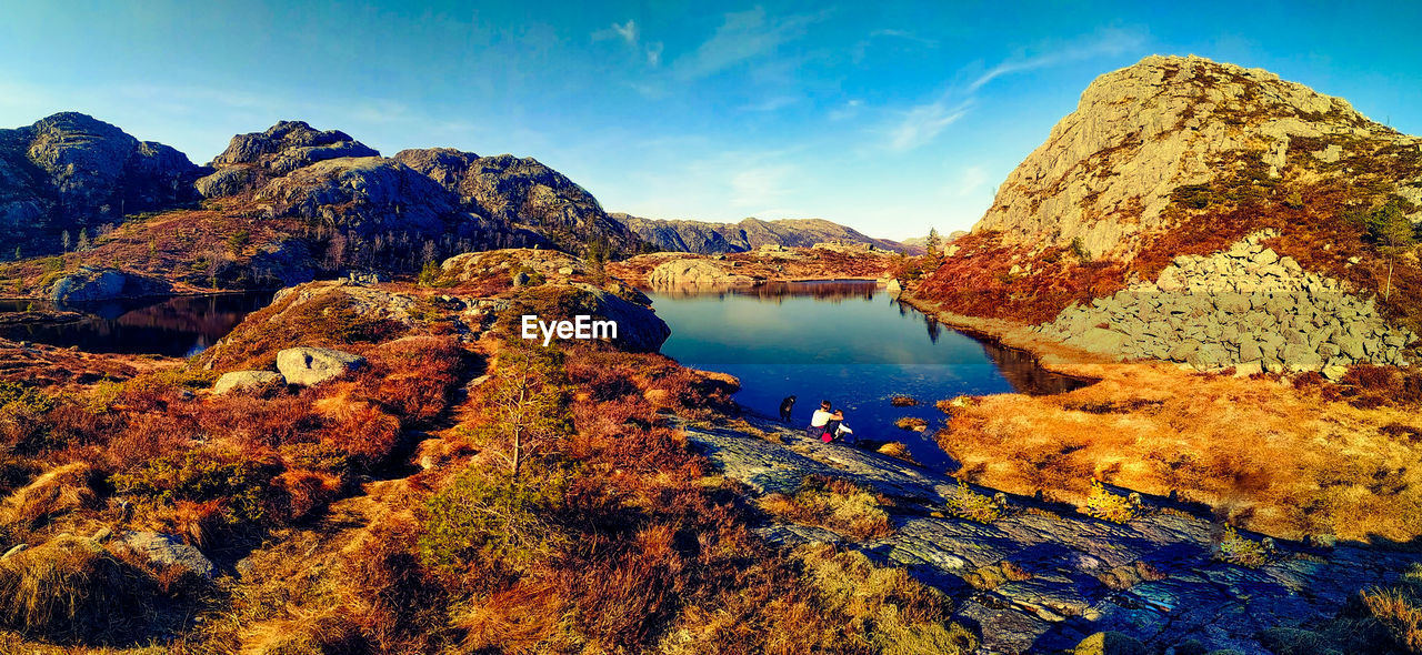 Scenic view of lake and mountains against blue sky