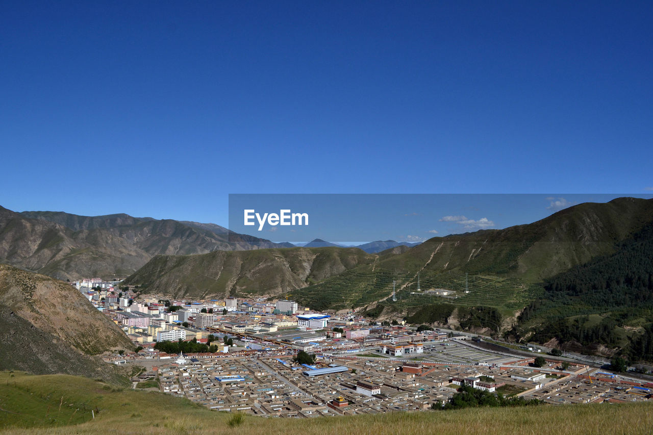 SCENIC VIEW OF TOWNSCAPE AGAINST MOUNTAINS
