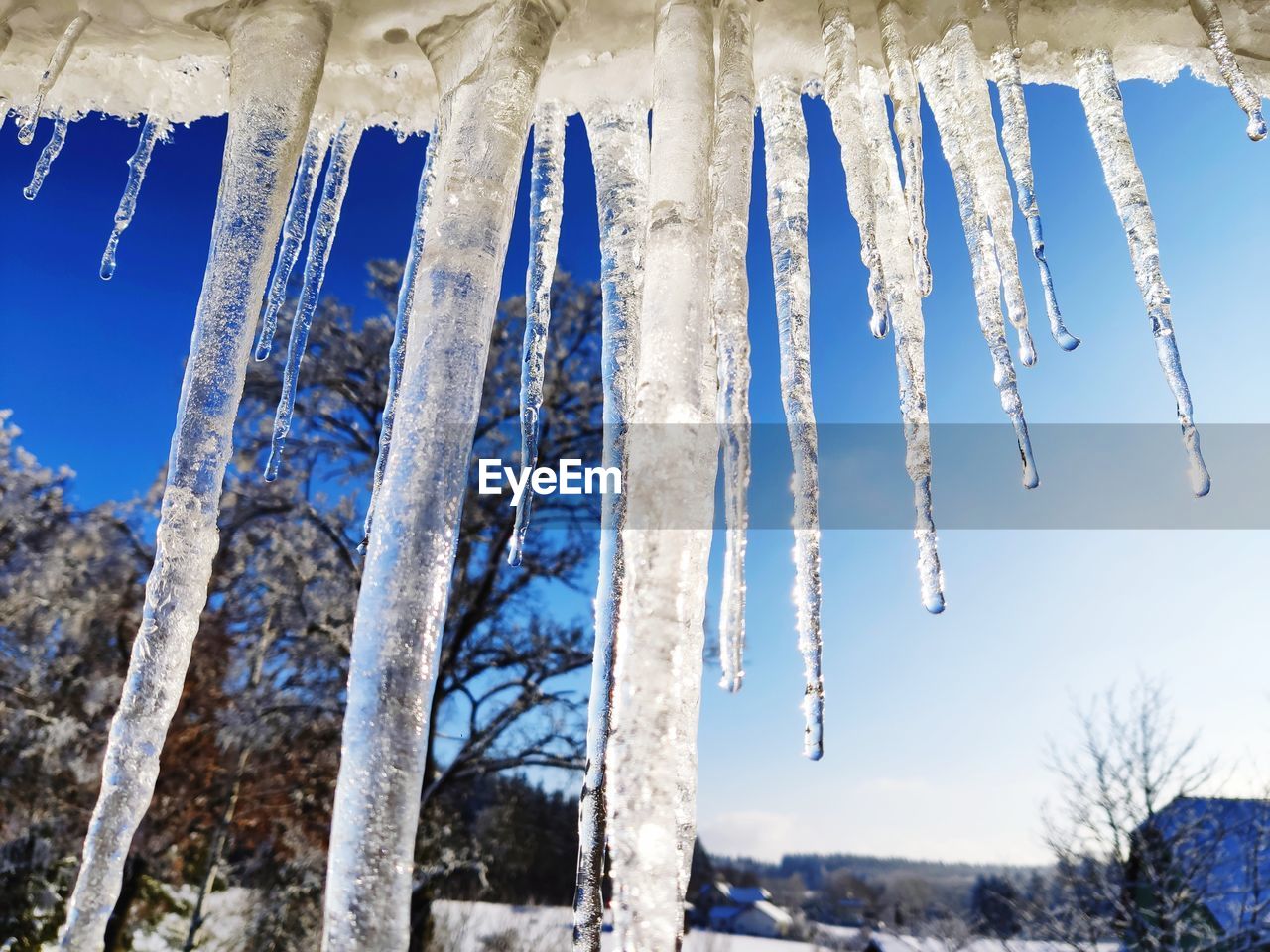 Low angle view of icicles against blue sky