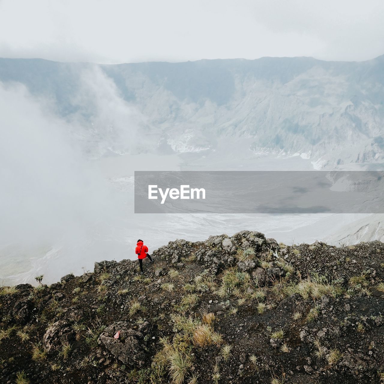 Man standing on rock against volcanic landscape