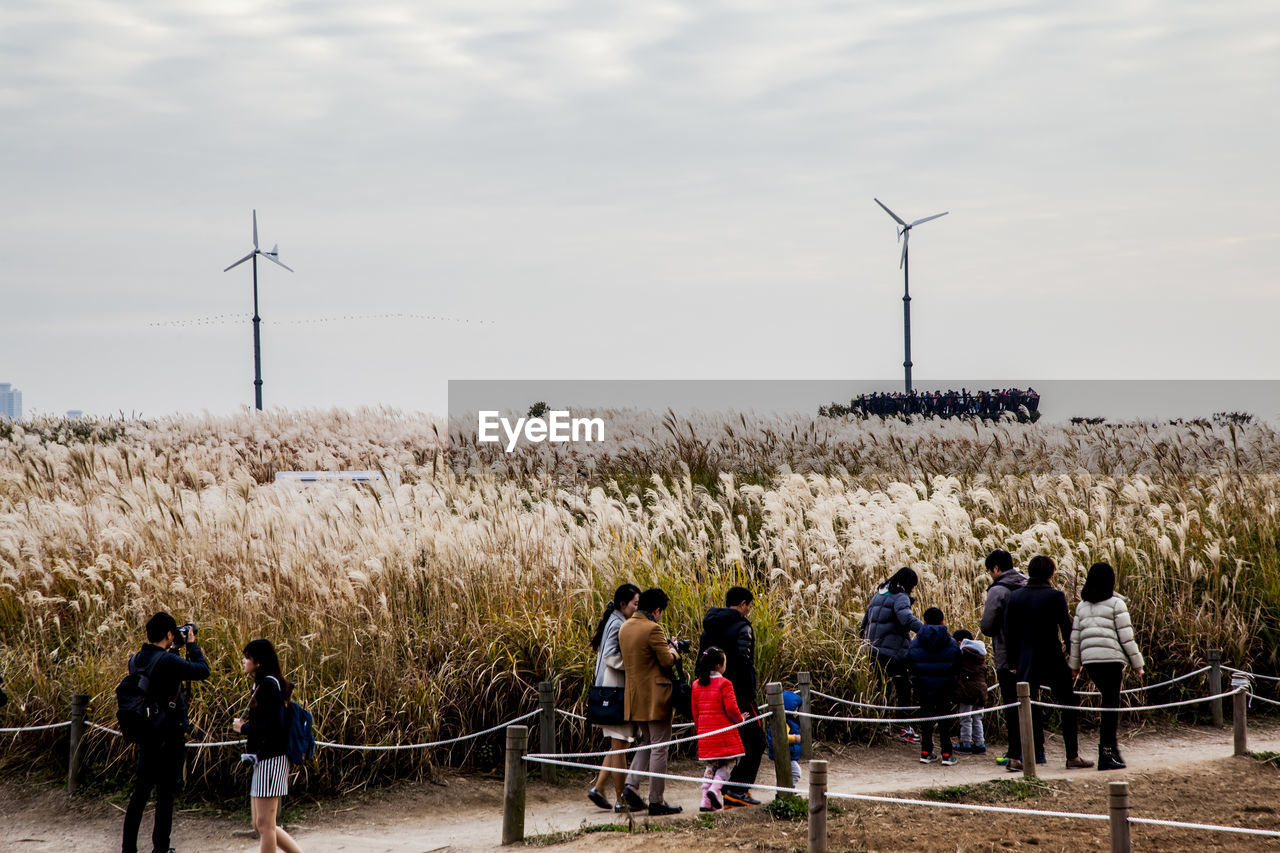 People walking by grass at sky park