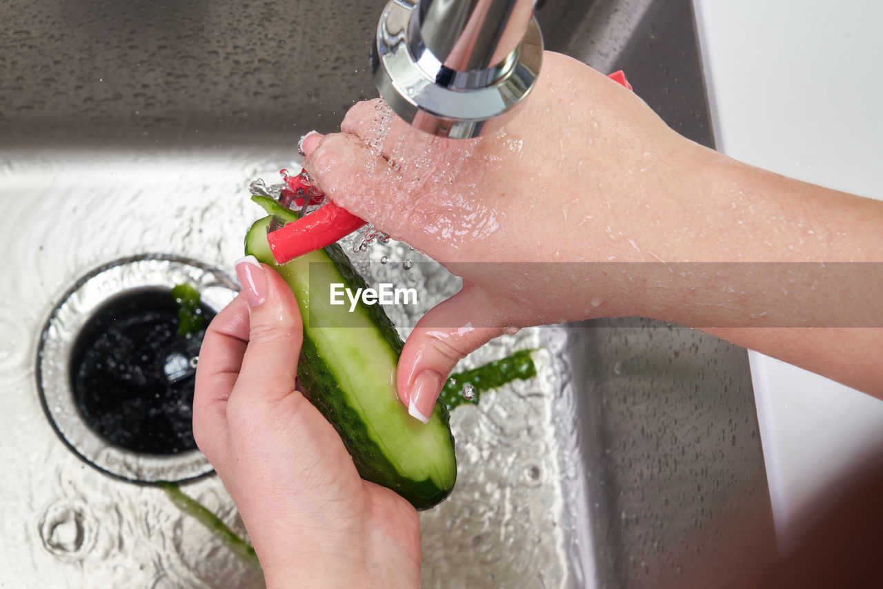 CROPPED IMAGE OF WOMAN HAND HOLDING WATER AT NIGHT