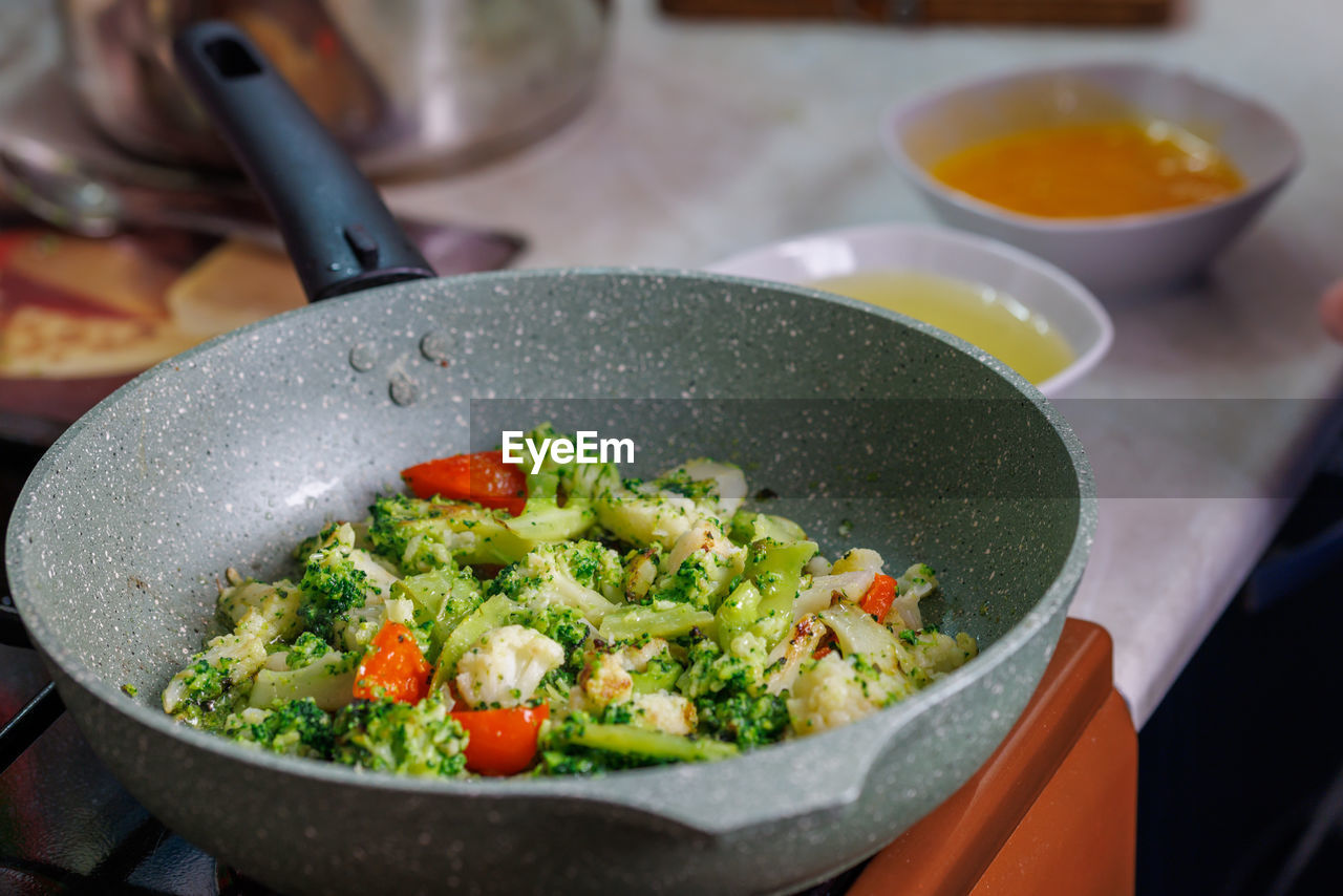 Close-up view of frying vegetables in pan without lid