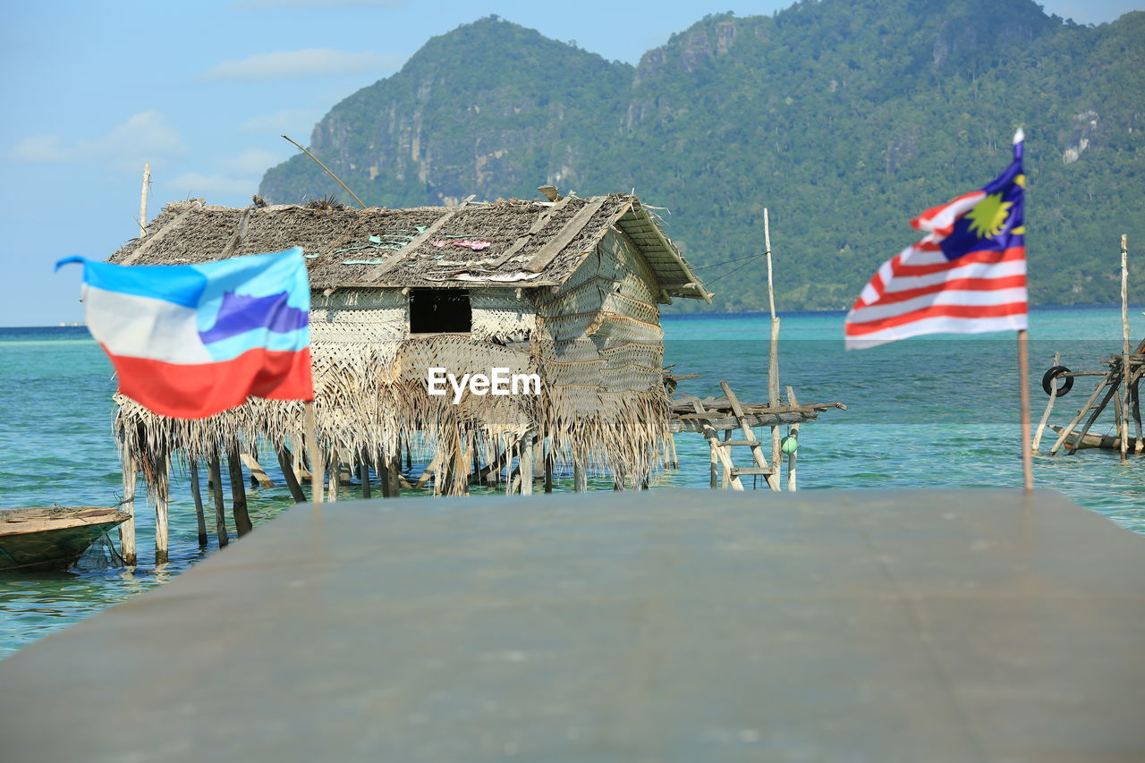 Flag by sea against mountains