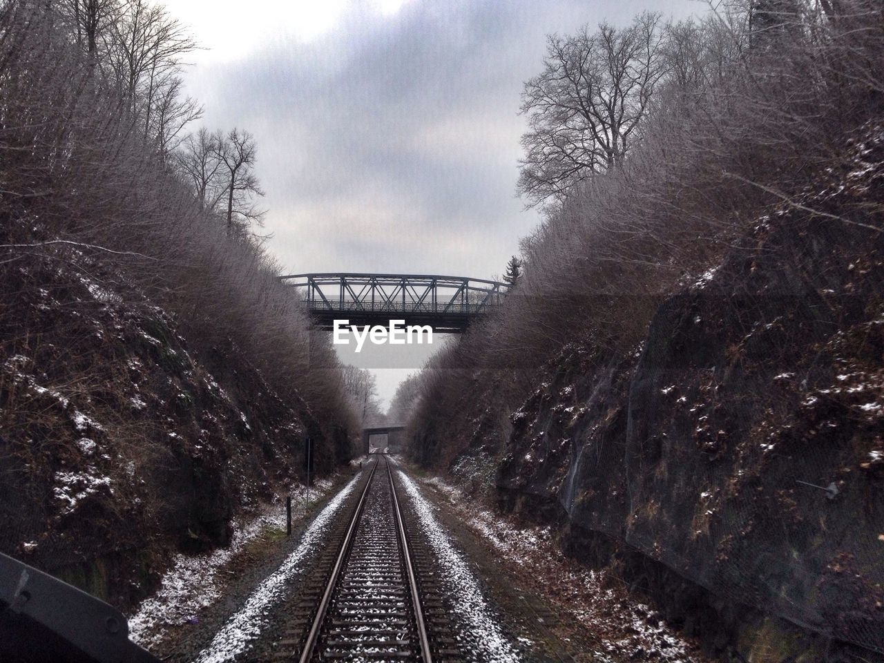 Bridge over railroad track against sky