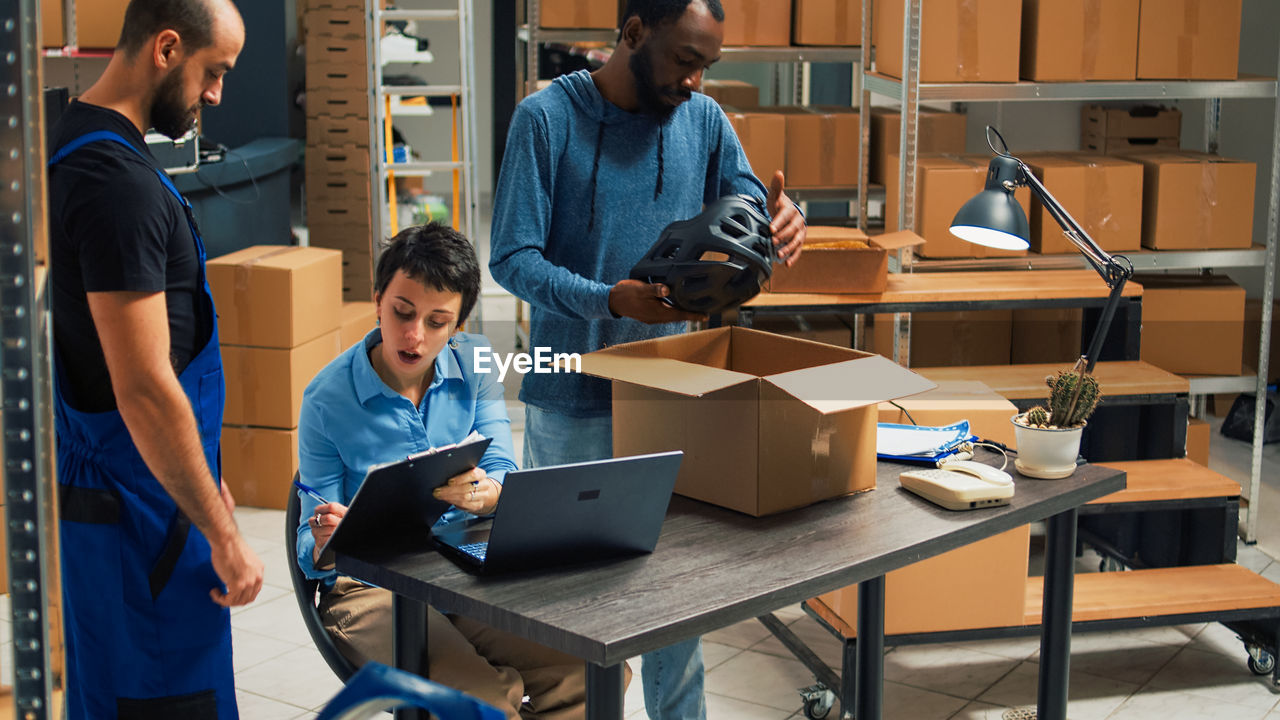 rear view of man using digital tablet while standing in office