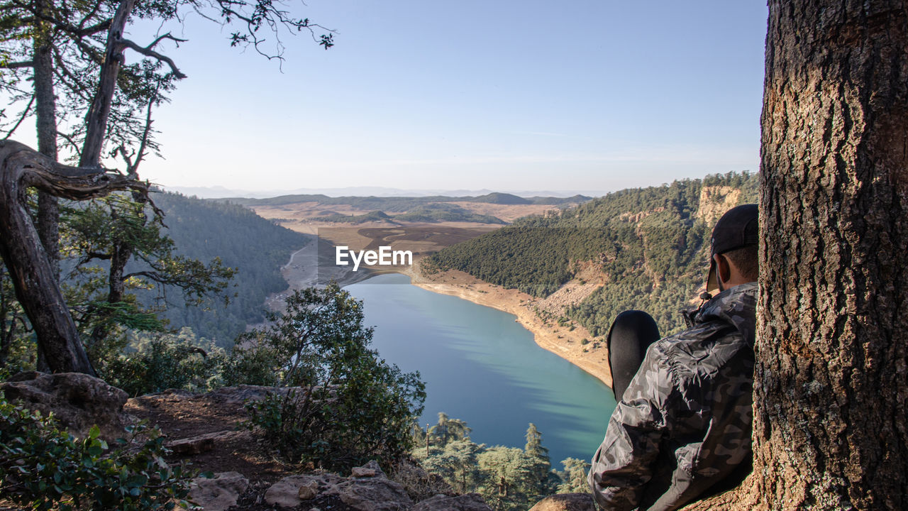 Hiking man looking at aguelmam azigza lake 