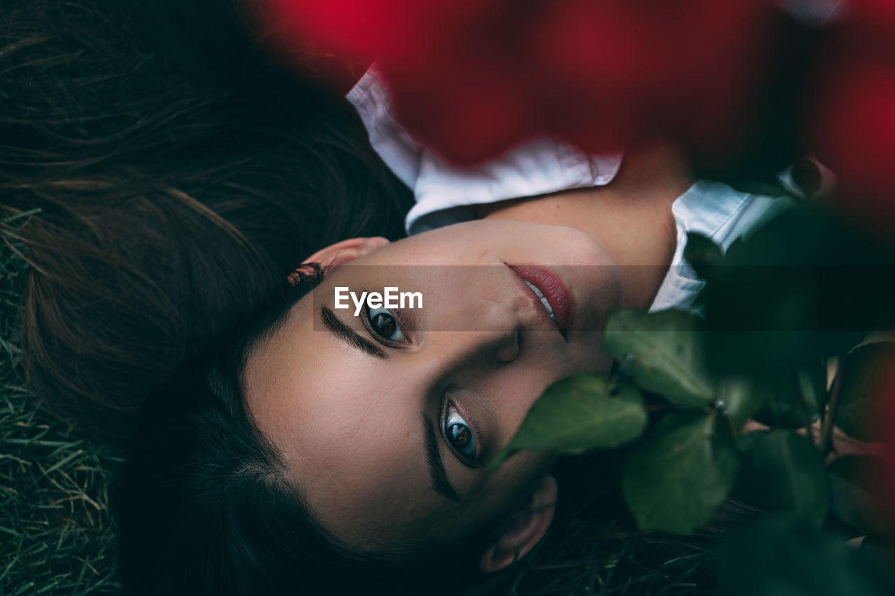 High angle portrait of woman lying on field