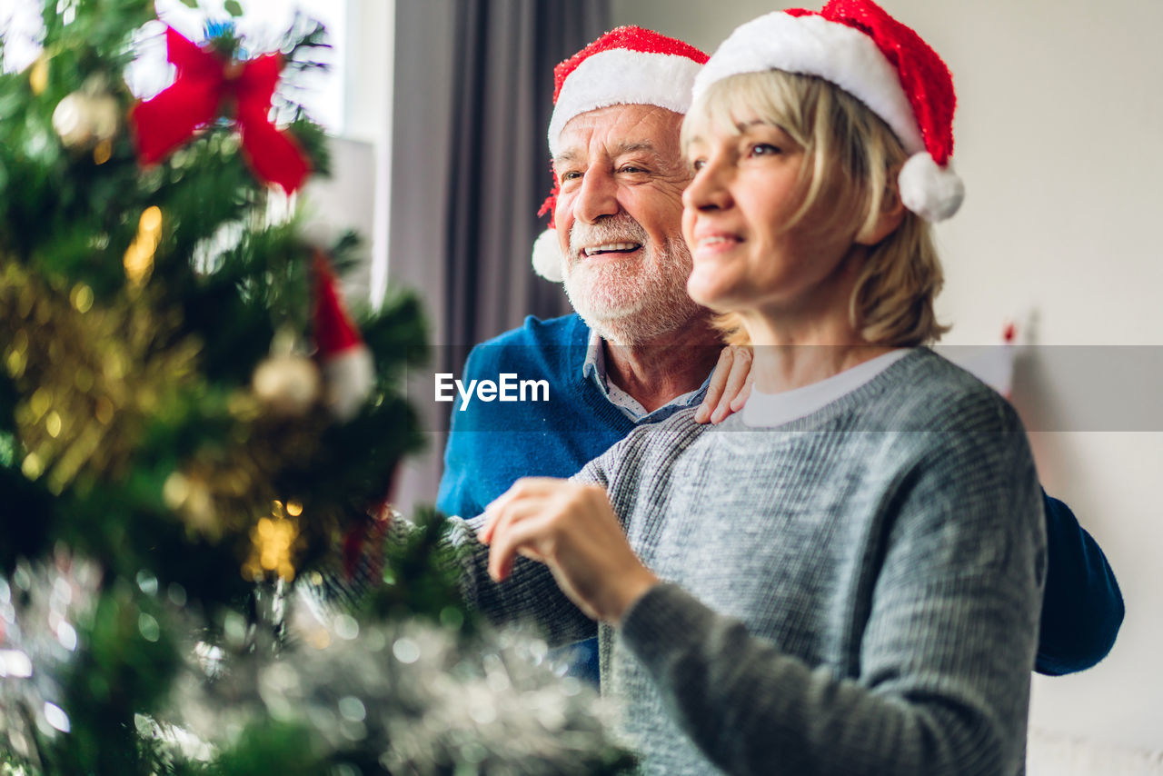 Couple decorating christmas tree at home