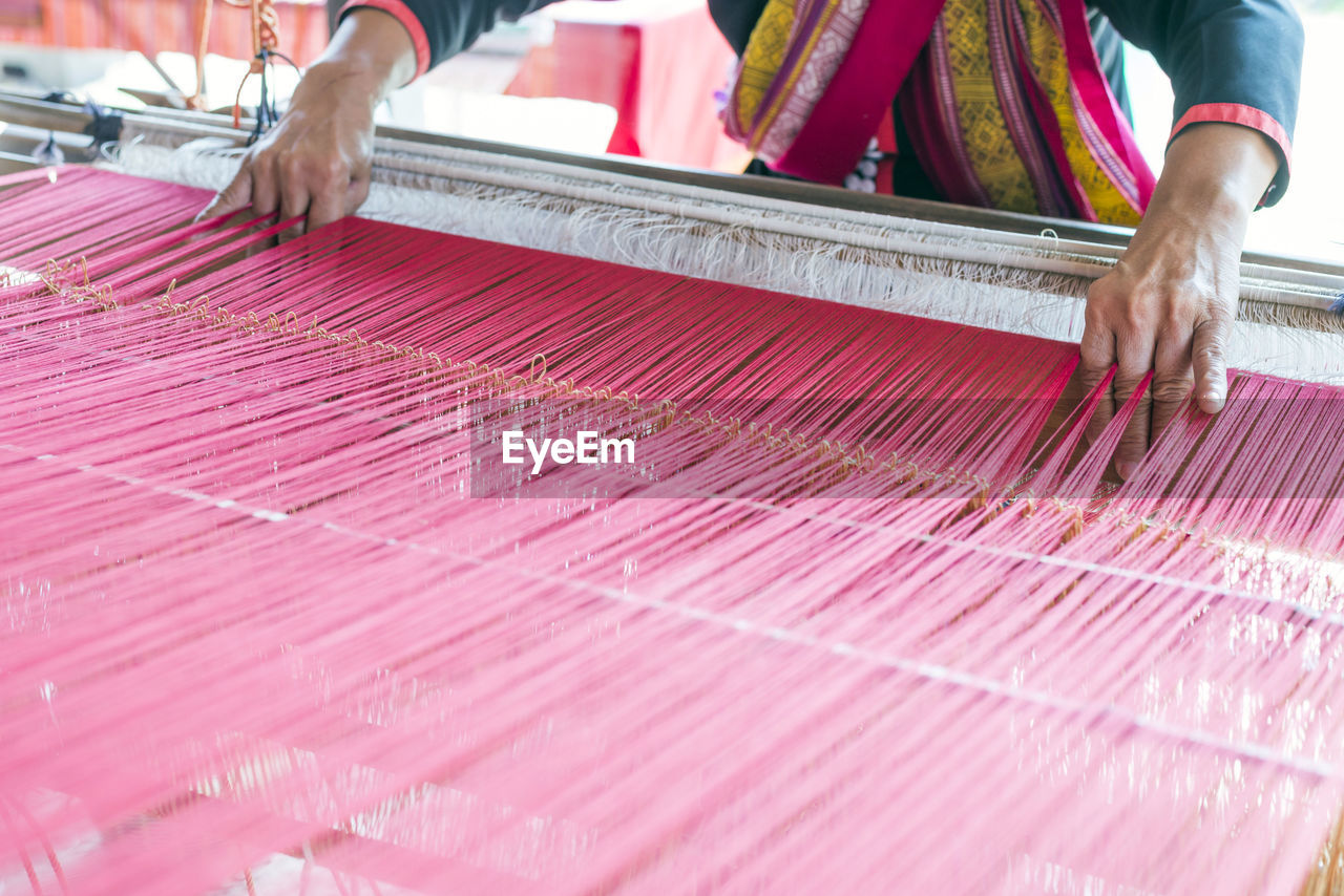 Close-up of female weaving cotton