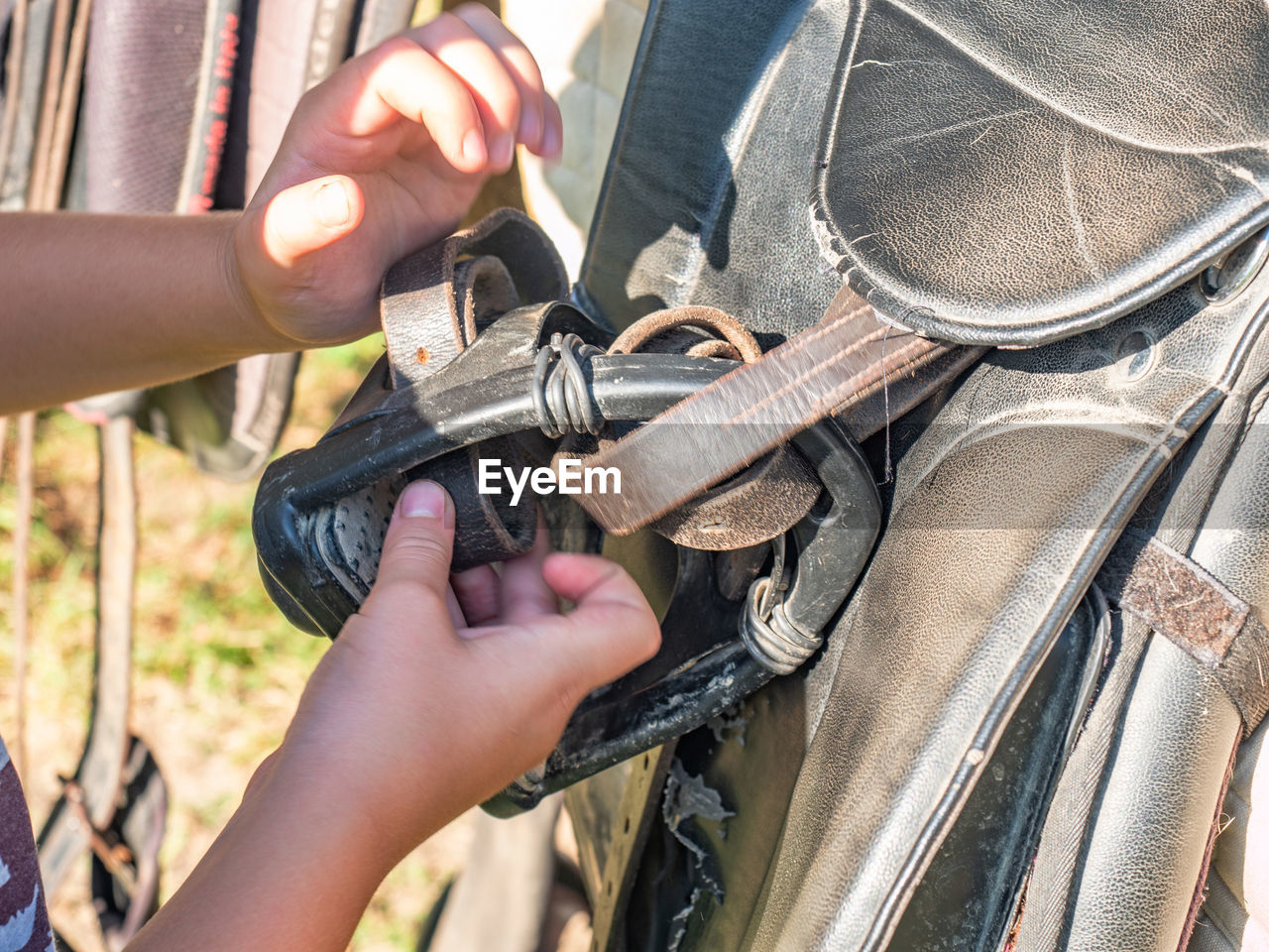 CLOSE-UP OF MAN WORKING ON METAL CHAIN